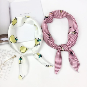 Detail of satin square scarves with fruit pattern and stripes in a lifestyle setting