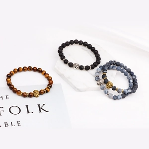 Tiger Eye and Lava Stone men's bracelets with gold lion heads on marble stone