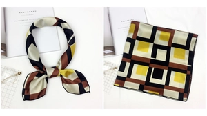 Detail of a square satin scarf with geometric color-block pattern and smooth silk texture