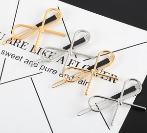 Detailed set of four metallic bow hair clips in matte and polished gold and silver finishes