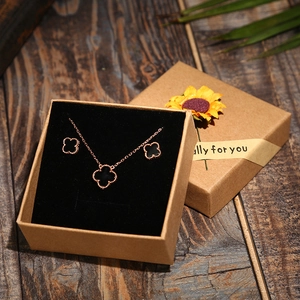 Detail of black clover jewelry set with rose gold finish in sunflower kraft gift box
