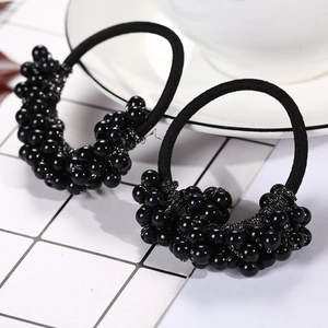 Detail shot of black braided elastic hair ties with elegant faux pearls and crystal beads
