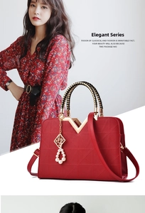 Detailed close-up of a bright red quilted handbag with woven handle and pearl charm