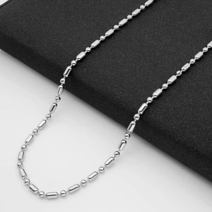 Polished silver stainless steel bead and cylinder link chain necklace on a dark backdrop