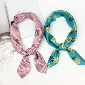 Women's silk satin neck scarf with crane stripe and pineapple patterns in flat lay