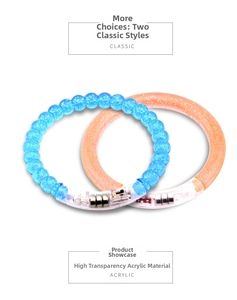 Detail view of two LED acrylic bracelets featuring transparent blue beads and orange smooth band