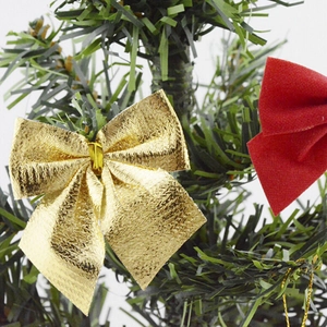 Détail de nœuds de Noël rouges et dorés avec feuille métallique et velours sur des branches