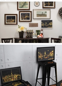 Modern black frames displaying city night scene scratch art on a cozy gallery wall