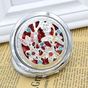 Detail of vintage round folding makeup mirror with hollow flower and dragonfly patterns