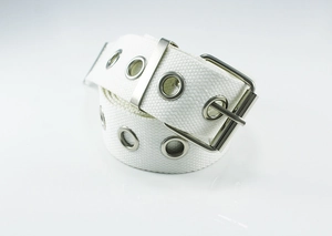 Detail of white canvas belt with double silver metal grommets and square pin buckle