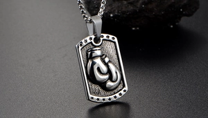 Macro detail of silver stainless steel dog tag pendant with boxing glove relief