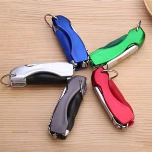 Five colorful mini nail clipper pens in blue, green, red, grey and silver on wood table