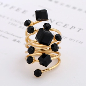 Detailed view of a multi-layer golden spiral ring set with faceted black gemstones