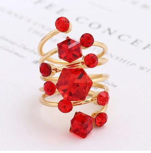 Close-up of golden multi-layer wrap ring featuring red crystal stones on white paper