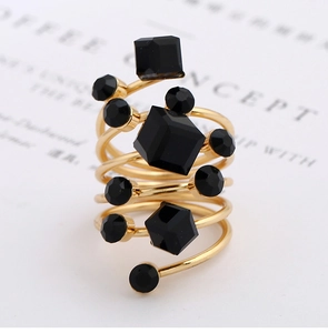 Macro detail of multi-layer gold spiral ring with faceted black crystal settings