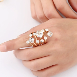 Detail view of gold spiral ring with multi-layer crystal stones on a model's hand