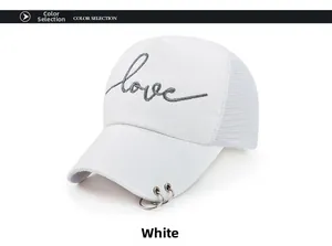 Détail de la casquette trucker blanche avec broderie 'love' et anneaux métalliques
