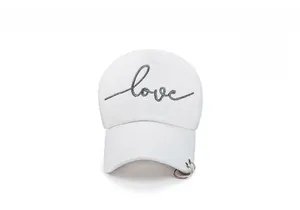 Vue de face d'une casquette blanche avec broderie love et anneaux métalliques sur le bord