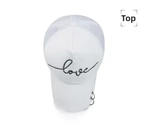 Vue de dessus d'une casquette blanche avec broderie love et anneaux métalliques argentés