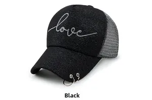 Détail d'une casquette en maille noire avec broderie love argentée et anneaux sur la visière