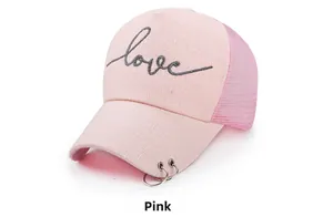 Détail de la casquette trucker rose avec broderie love et anneaux sur la visière