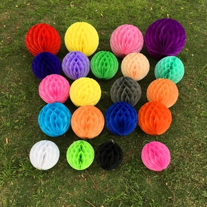 Flat lay of colorful honeycomb paper ball decorations in sixteen shades on grass background