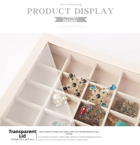 Detail view of cream jewelry organizer with glass lid and multiple soft compartments