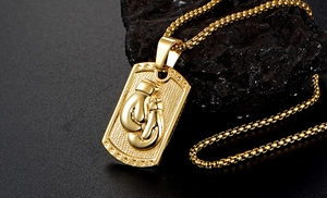 Detail view of gold boxing glove pendant on stone with round box chain necklace
