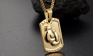 Detail of golden boxing glove relief on a textured rectangular pendant with box chain
