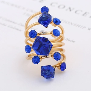 Macro shot of multi-layer spiral gold ring with faceted blue crystal and small gems