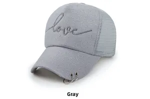 Détail d'une casquette de baseball grise avec anneaux métalliques et broderie love
