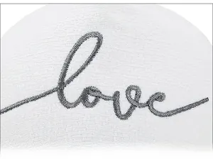 Gros plan sur la broderie love noire sur le tissu en mesh blanc de la casquette de baseball
