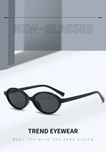 Detail view of oval black sunglasses with high-gloss frame and premium lenses