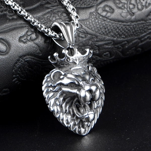 Polished silver stainless steel lion head pendant with crown on textured background
