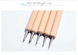 Détail de 5 stylets de gaufrage en bois avec têtes sphériques en métal de tailles variées