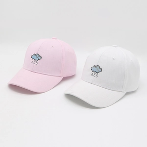 Detail of pink and white breathable baseball caps with cloud embroidery and adjustable fit