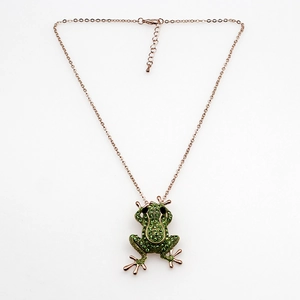 Détail d'un collier en or rose orné d'un pendentif grenouille en zircons verts