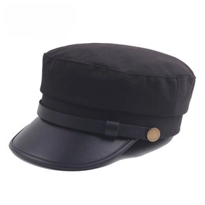 Détail du chapeau militaire avec visière en simili cuir noir et bouton en métal rétro