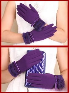 Detail of purple winter gloves featuring soft faux fur trim, lace, and bow decoration