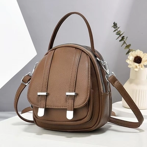 Detail of dark brown lychee textured mini backpack with silver hardware and leather handle