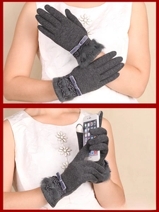 Detail of dark grey thermal touchscreen gloves with faux fur trim and bow decoration