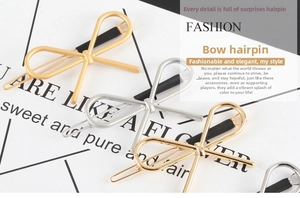 Close-up of bow-shaped alloy hair clips in matte gold, silver, and glossy gold finishes