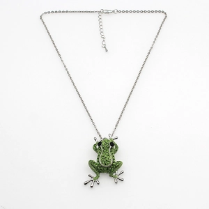Gros plan d'un collier en argent avec pendentif grenouille verte orné de strass brillants