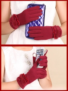 Detail of dark red thermal gloves with faux fur trim and elegant satin bow accents