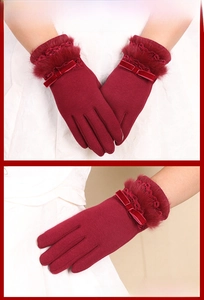 Close-up of warm winter gloves featuring faux fur trim, lace details, and a velvet bow decoration