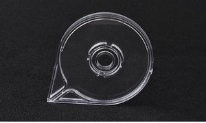 Close-up of a round transparent nail art striping tape dispenser on a black background