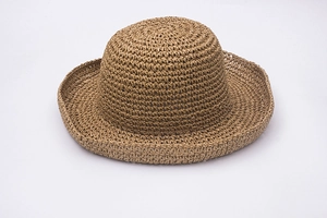 Close-up of hand-crocheted raffia straw hat showing detailed weave and foldable wide brim