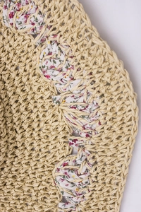 Macro detail of handmade straw hat weaving with purple floral fabric trim