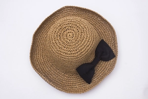 Handmade woven raffia straw hat for women with a black ribbon bow for beach sun protection