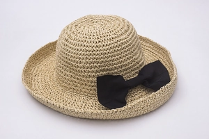Detail of hand-woven raffia sun hat texture with a stylish black bow decoration